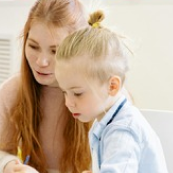 Teacher helping child learn at Playful Scholars preschool in Midland, MI